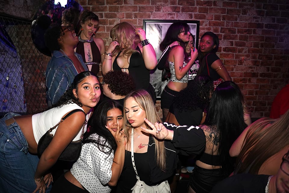 Group of friends posing against the brick wall